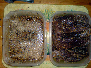 The discarded curing mixture, and cured strips of meat. Notice how dark the meat now is.